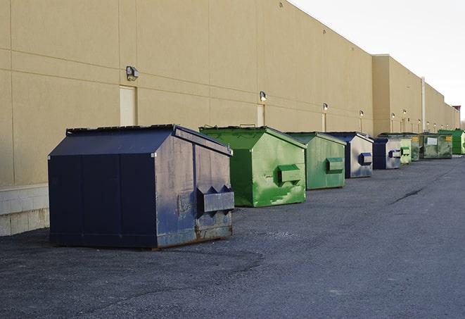 multiple construction dumpsters at a worksite holding various types of debris in Archer